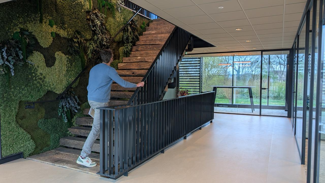 Collega loopt de trap op naar de werkvloer bij Lincon